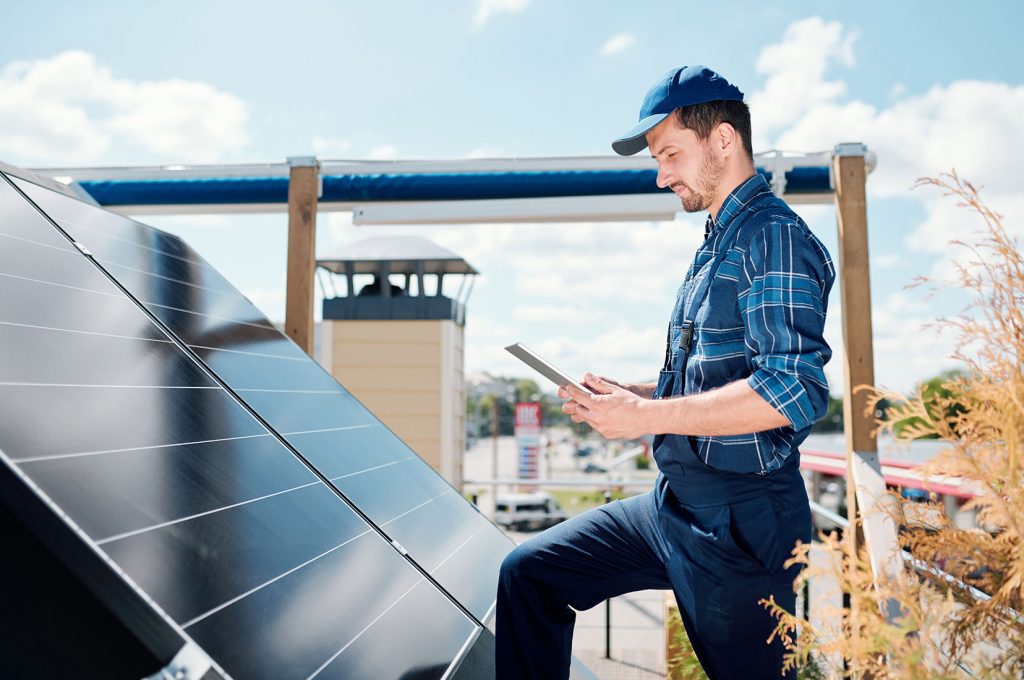 A man wearing blue cap looking at the solar panels